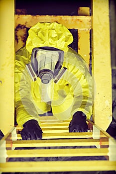 Specialist in protective suit and mask on ladder