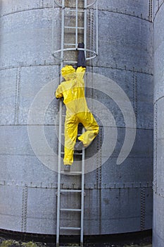 Specialist in protective uniform going up a metal