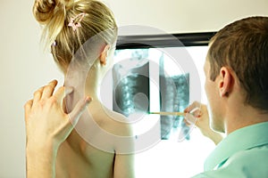 Specialist showing x-ray image to the kid patient