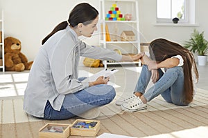 Specialist trying to help sad, stressed child to solve behaviour and learning problems