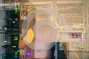 The specialist works in a data center. A man maintains computer equipment in server racks. Service modern technical platform. The