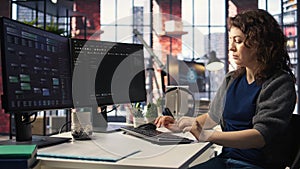 IT specialist at workstation programming on monitor and writing lines of code