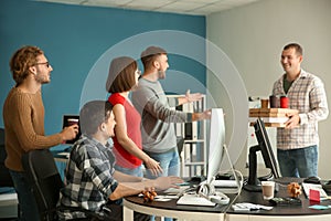 IT specialists meeting colleague with food in office