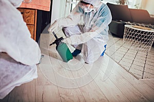 Specialists in protective suits do disinfection or pest control