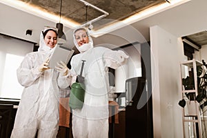 Specialists in protective suits take samples from surfaces in the home to test for a corona virus