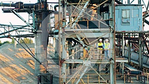 Specialists are standing inside of a metal construction in port