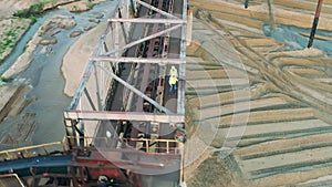 Specialists are walking along the bridge in a sand quarry