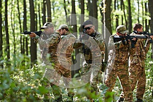 A specialized military antiterrorist unit conducts a covert operation in dense, hazardous woodland, demonstrating photo