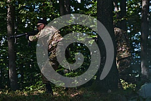 A specialized military antiterrorist unit conducts a covert operation in dense, hazardous woodland, demonstrating photo