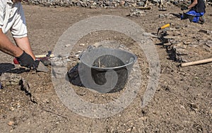 Specialized workers digging with trowel on archaeological excavation