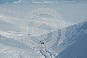 Specially modified 4x4 cars driving offroad in snow in the highlands of Iceland