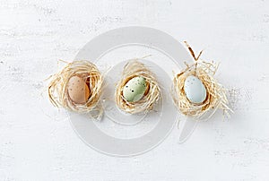 Speckled Easter Eggs in nests and in a row flat lay arrangement