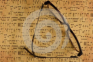 Spectacles eye protectors on randomly placed music notes from computer showing antique sepia effects from printing on inkjet