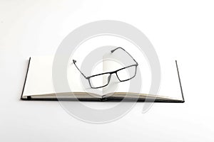 Spectacles or eyeglasses and diary on white background