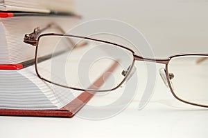 Spectacles laying on the closed book