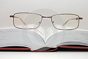 Spectacles laying on the open book