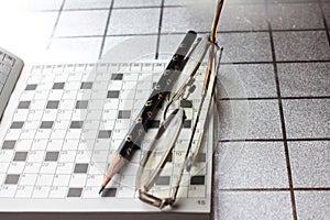 Spectacles, pencil, crossword