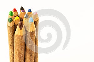 SPECTACULAR AND ADORABLE CRAFTSMANSHIP COLORED CRAYONS RUSTICALLY MADE WITH TREE BRANCHES ON A WHITE BACKGROUND photo