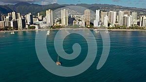 Spectacular aerial view of sailboat offshore of Waikiki beach in Hawaii.