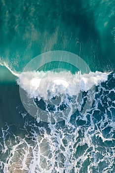 Spectacular aerial view of a surfer taking on waves in a blue ocean