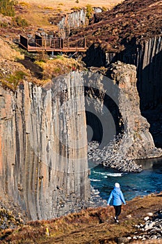 Spectacular basaltic columns and river canyon with blurred tourist