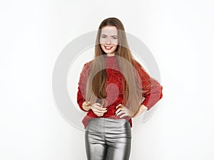 Spectacular blonde woman in red blouse silver leather pants posing in front of white wall. Graceful girl gorgeous long hair having
