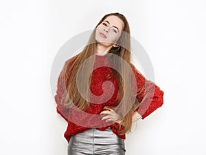 Spectacular blonde woman in red blouse silver leather pants posing in front of white wall. Graceful girl gorgeous long hair having