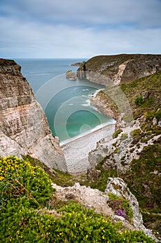 Spectacular cliffs in Cap Frehel, Pointe du Jas, small beach and island Amas du Cap on a cloudy day in summer