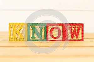 Spectacular colorful letters on wooden cubes on a wooden board with the word KNOW