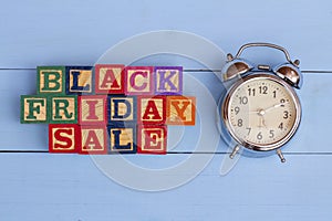 SPECTACULAR CONCEPT OF BLACK FRIDAY AND SALES WITH WOODEN CUBES AND WITH WOODEN SURFACE WITH OLD ALARM CLOCK