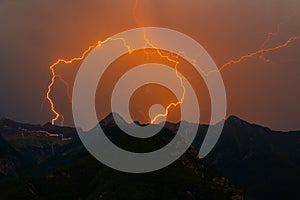 Spectacular double lightning bolt strike in mountain peak silhou