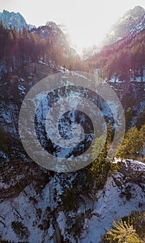 Spectacular drop down view of waterfall falling over rocky forest ledge.