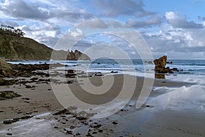 Spectacular lonely beach with rock formations in the spanish area of asturias in winter at low tide