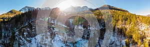 Spectacular mountain panorama with waterfall falling across forest ledge.