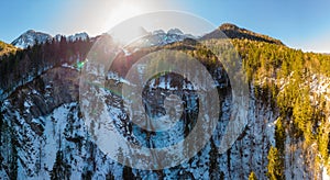 Spectacular mountain panorama with waterfall falling across forest ledge.