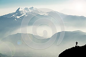 Spectacular mountain ranges silhouettes. Man reaching summit enjoying freedom. View from Top of Mount Corno di Tres