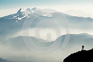 Spectacular mountain ranges silhouettes. Man reaching summit enjoying freedom. View from Top of Mount Corno di Tres