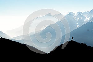 Spectacular mountain ranges silhouettes. Man reaching summit enjoying freedom. View from Top of Mount Corno di Tres