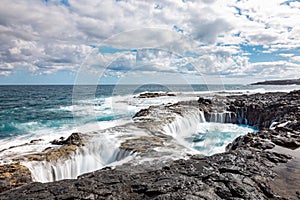 Spectacular natural phenomenon of Bufadero de la Garita where the water goes up and down in the hole with every wave, Gran Canaria photo