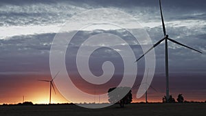 Spectacular orange sunset with modern wind turbines in slow-mo