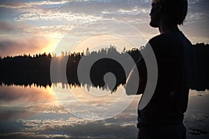 A young man watches the sunset over Crocket Cove in Stonington, Maine. photo