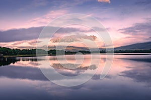 Spectacular reflection of the mountains on a lake with mist under the midnight sun, fairy tale atmosphere in the Vesteralen