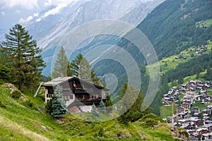 Spectacular summer alpine landscape, mountain swiss wooden chalet with high mountains in background, Zermatt