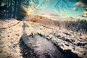 Spectacular sunset over snow covered country road