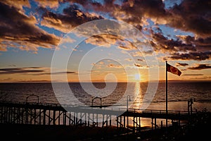Spectacular sunset at White Rock pier with Canada flag