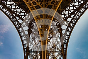 Spectacular view on the metal arcs of the Eiffel tower.