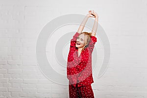 Spectacular woman in trendy sleepwear stretching with smile. Enthusiastic girl enjoying good morning and posing on white