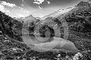 Spectacular, wonderful and evocative landscape of a lake in the Pyrenees surrounded by mountains and snow-capped peaks of Benasque