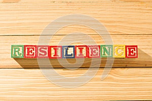 Spectacular wooden cubes with the word RESILIENCE on a wooden surface