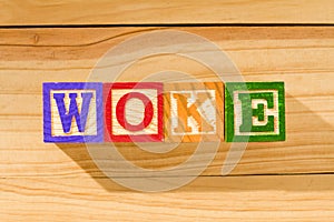 Spectacular wooden cubes with the word WOKE on a wooden surface